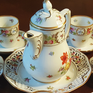 a decorative bone china tea set on a wooden tabletop